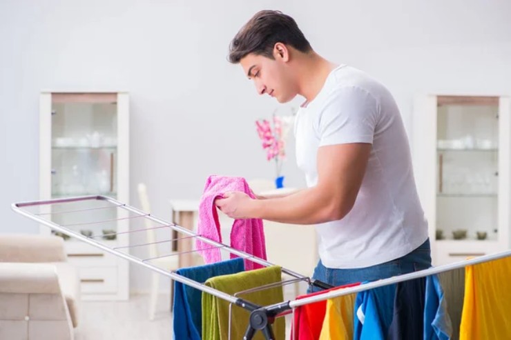 Un ragazzo mentre stende i panni (Depositphotos)